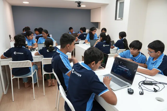 Students work in small groups with laptops in a ClassPe classroom.